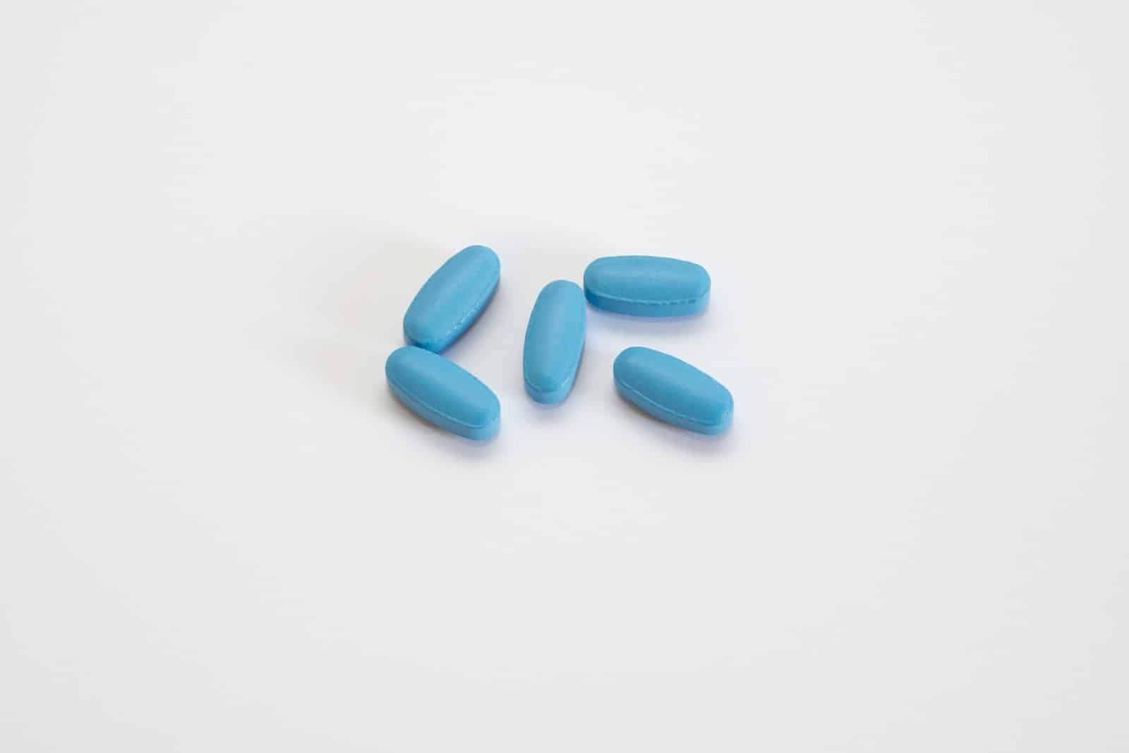 a group of blue pills sitting on top of a white table